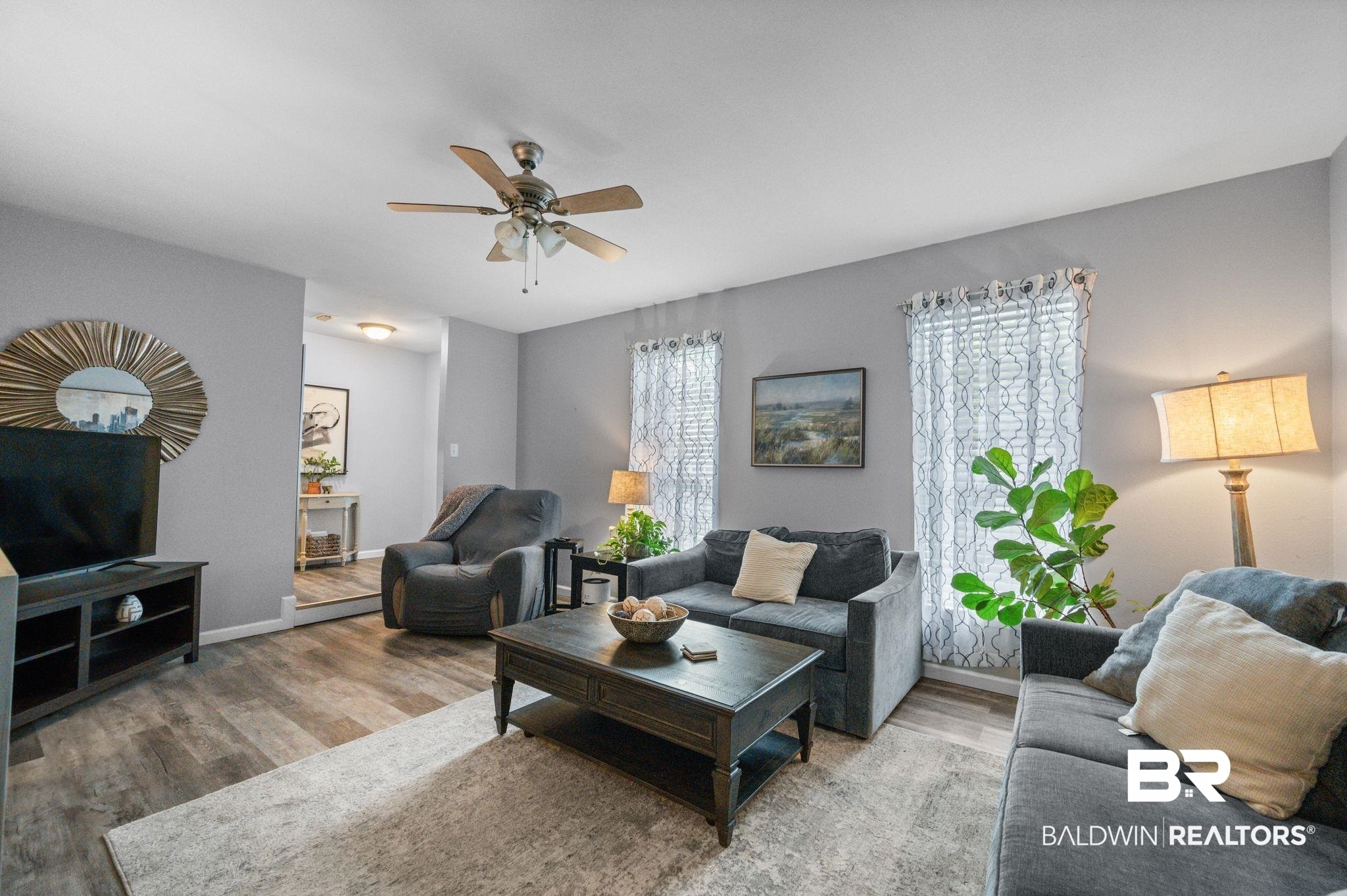 4724 Wicker Way Mobile, AL 36609 - Photo 4 of 36 Living room featuring wood-finish flooring, light gray walls, a ceiling fan with light fixture, and two windows with blinds