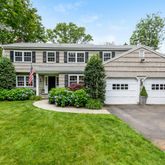 a view of house with a yard and potted plants