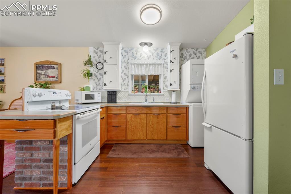 183 Beaver Pond Road Divide, CO 80814 - Photo 12 of 28 a kitchen with stainless steel appliances granite countertop a refrigerator a sink dishwasher and white cabinets with wooden floor