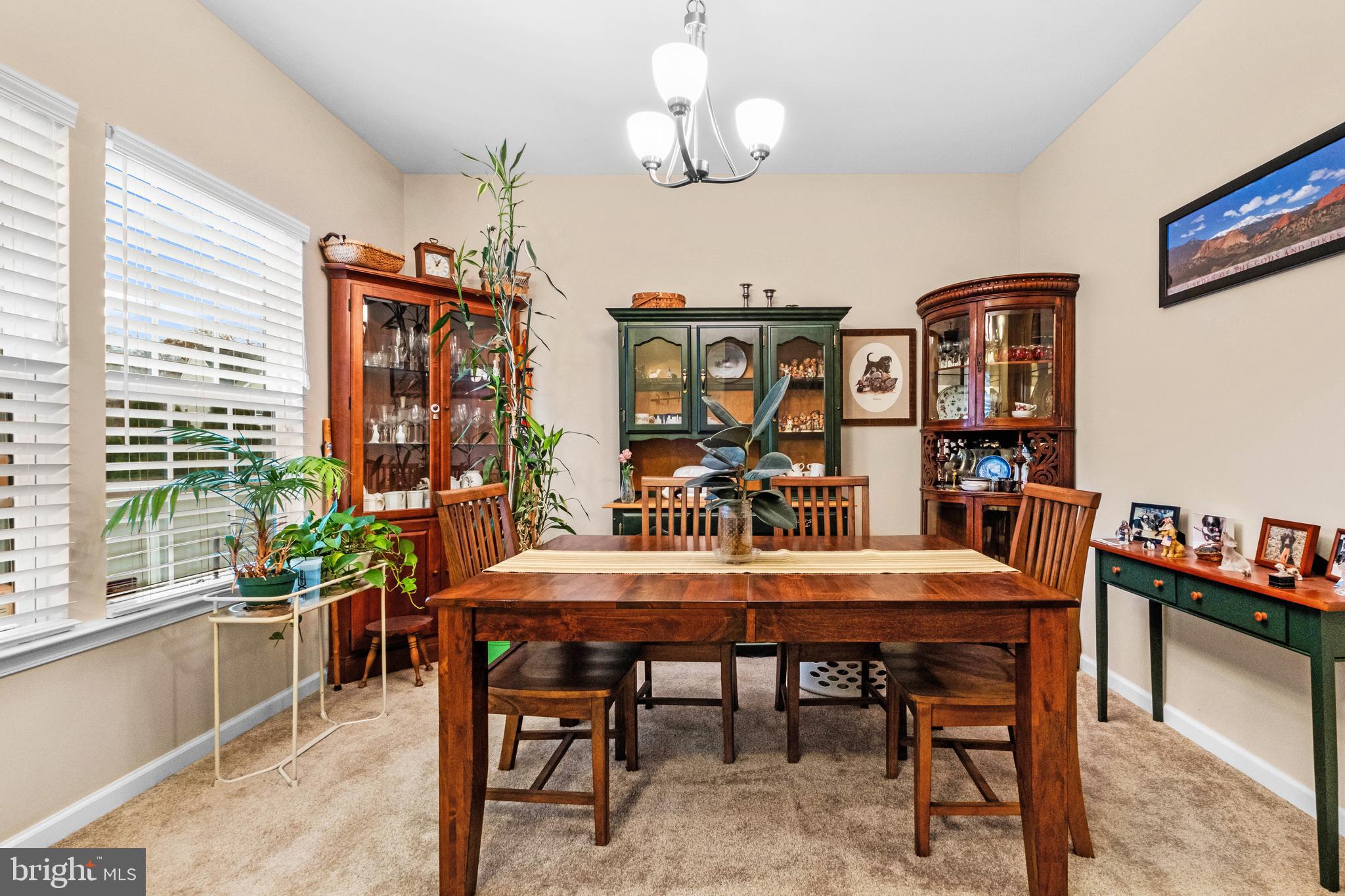 19 Vaughn Way Burlington, NJ 08016 - Photo 6 of 43 a dining room with wooden floor a chandelier a wooden table and chairs