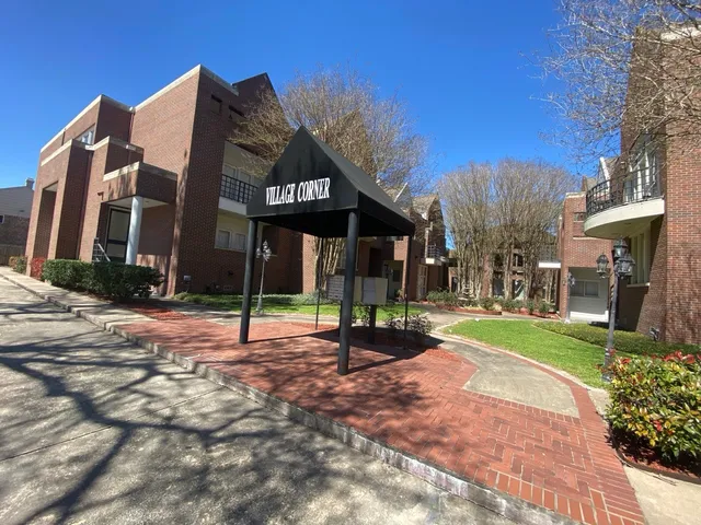a street view with a building and trees in the background