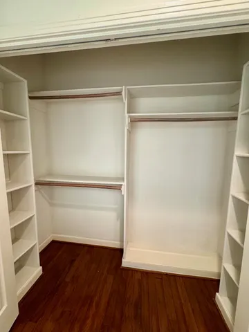 a view of walk in closet with empty racks