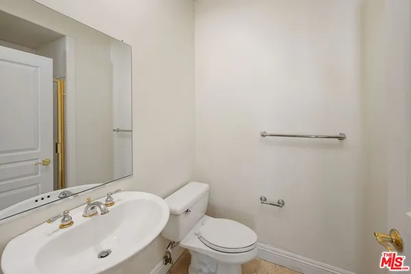 a bathroom with a sink a toilet and a mirror