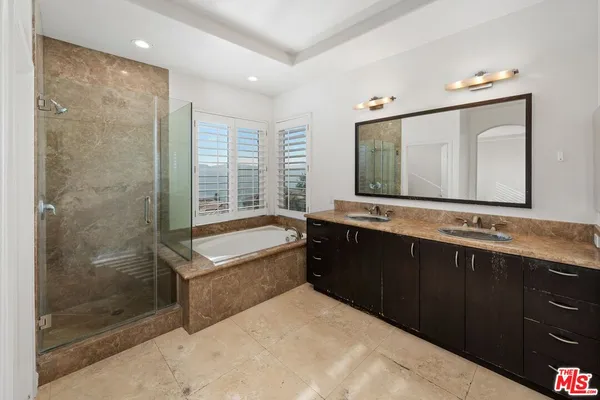 a bathroom with a granite countertop sink a toilet a mirror and shower