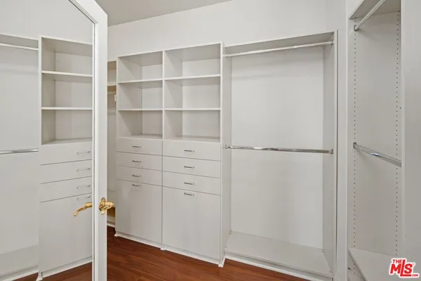 a view of walk in closet with empty racks
