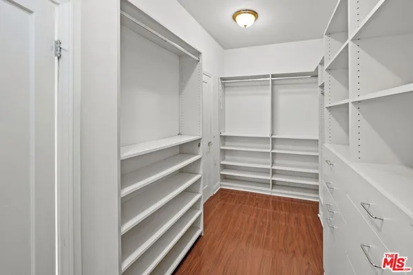 a view of walk in closet with empty racks