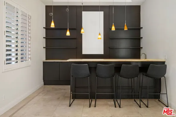 a kitchen with a refrigerator and table chairs
