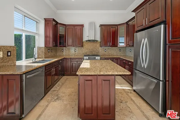 a kitchen with a sink a refrigerator and cabinets