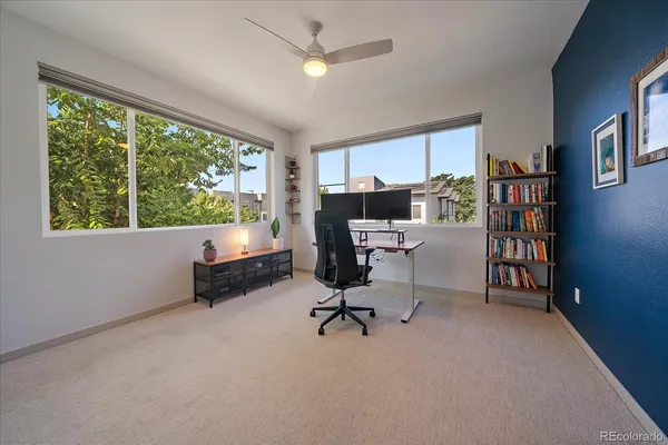 a view of a workspace with furniture and a window