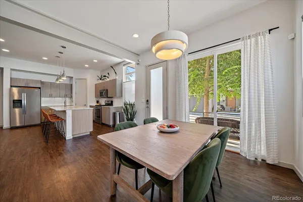 a view of a dining room and livingroom with furniture wooden floor a chandelier