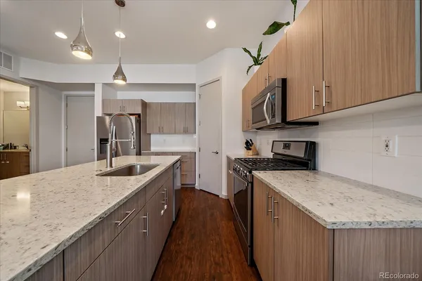 a kitchen with stainless steel appliances granite countertop a sink stove and refrigerator