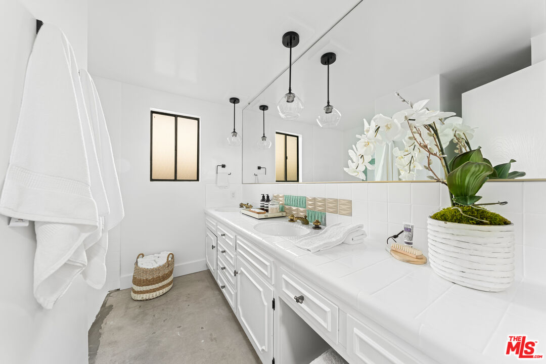 18440 Wakecrest Drive Malibu, CA 90265 - Photo 18 of 29 a bathroom with a granite countertop sink a mirror and a potted plant