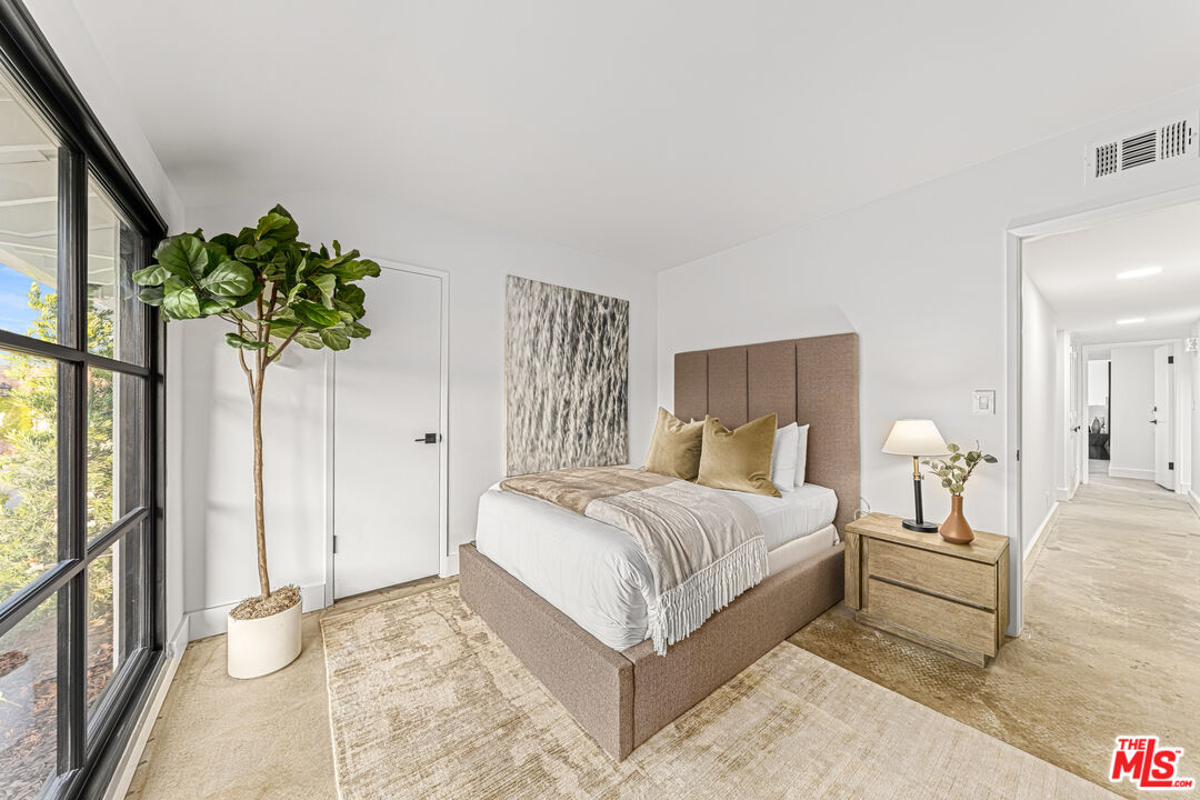 18440 Wakecrest Drive Malibu, CA 90265 - Photo 22 of 29 a bedroom with a bed table and a potted plant