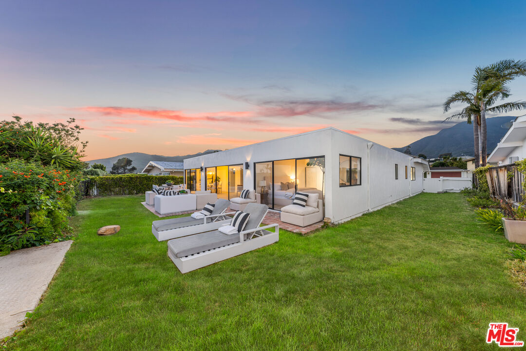 18440 Wakecrest Drive Malibu, CA 90265 - Photo 26 of 29 a view of a patio with table and chairs with wooden floor and fence