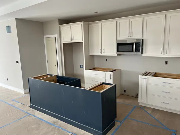 a kitchen with stainless steel appliances granite countertop a refrigerator and white cabinets