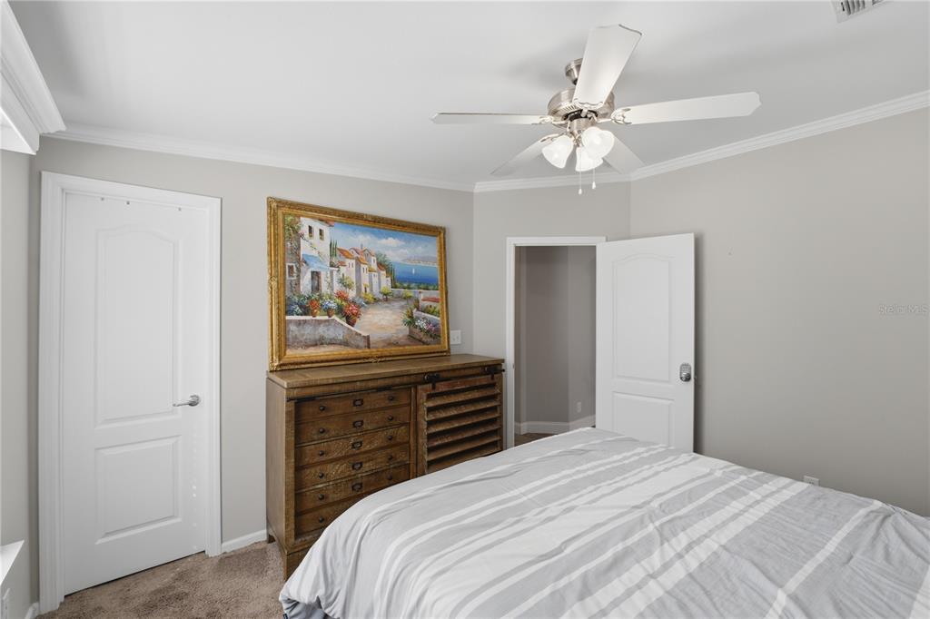 6844 Chad Jason Road St. Cloud, FL 34773 - Photo 38 of 59 a bedroom with a bed and a chandelier
