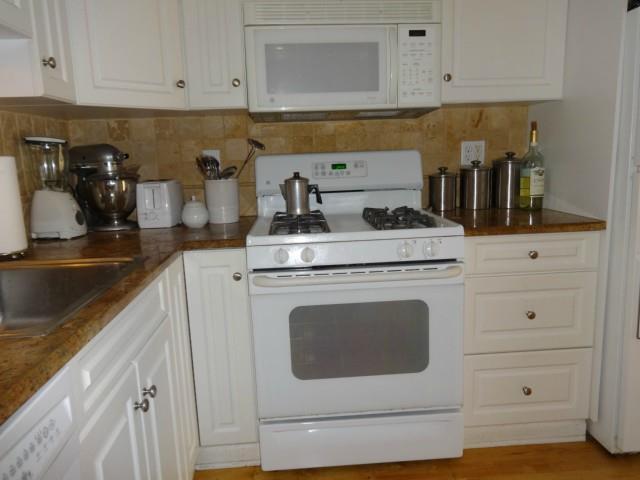 42 Olcott Way, Unit 42 Ridgefield, CT 06877 - Photo 1 of 1 a kitchen with granite countertop white cabinets and white appliances