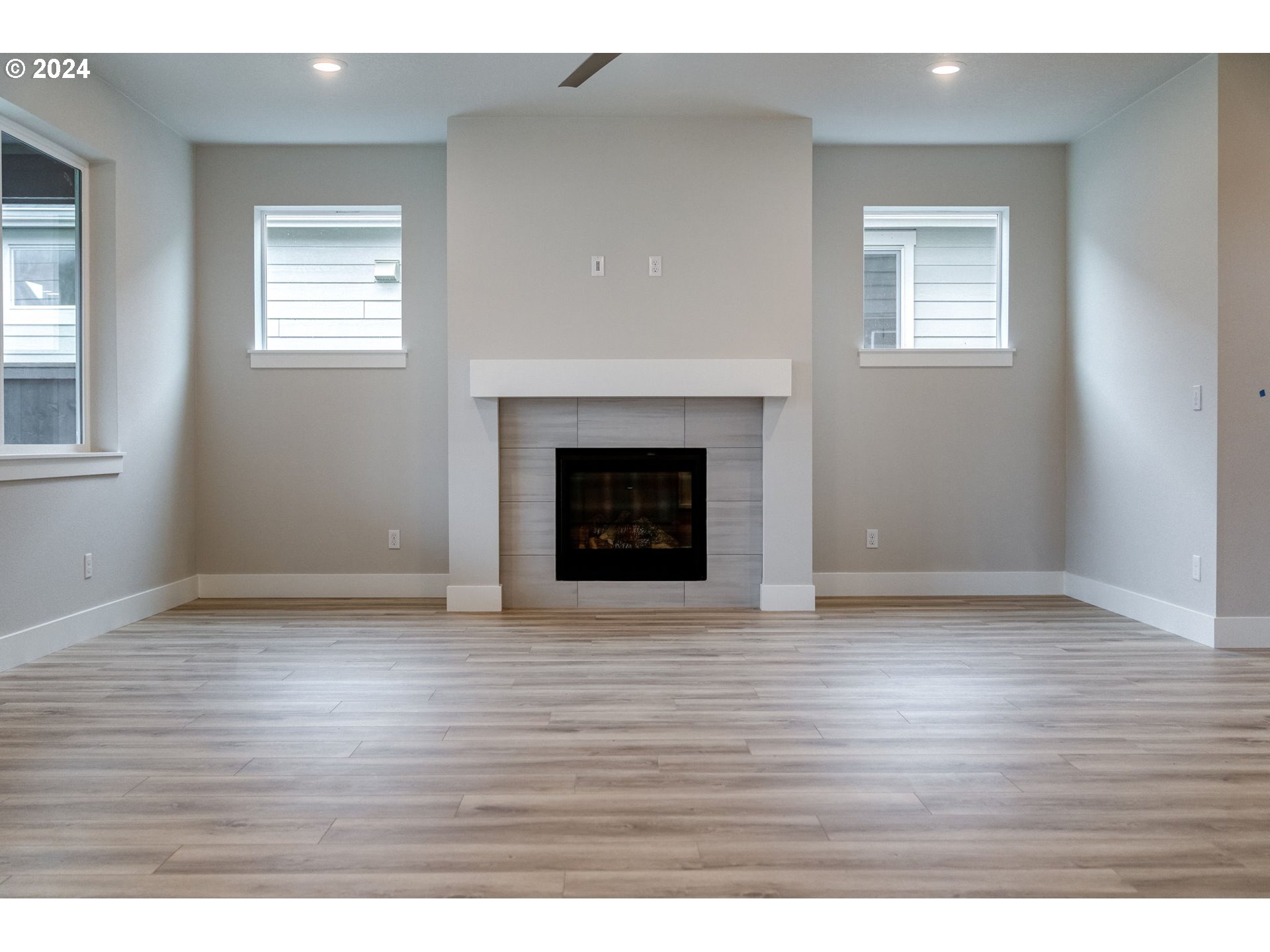 3610 South 44th Avenue Ridgefield, WA 98642 - Photo 29 of 38 an empty room with wooden floor fireplace and windows