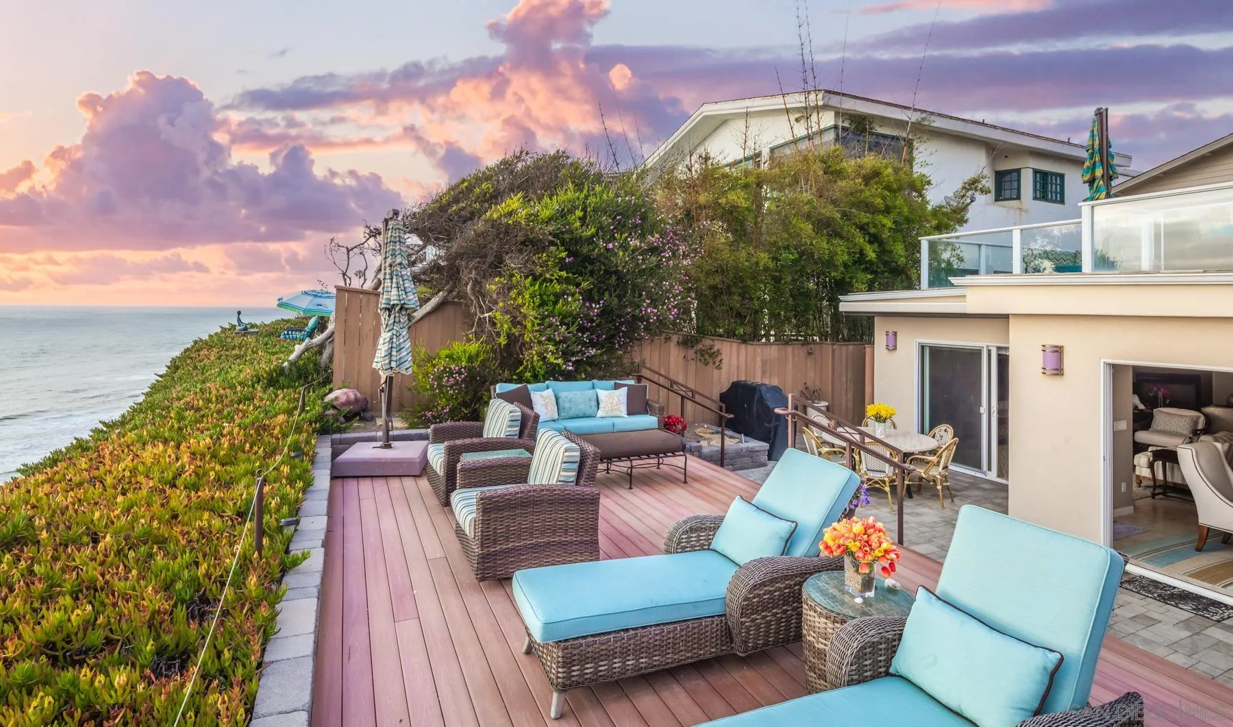 258 Neptune Avenue Encinitas, CA 92024 - Photo 12 of 26 a view of a patio with couches table and chairs under an umbrella with a fire pit