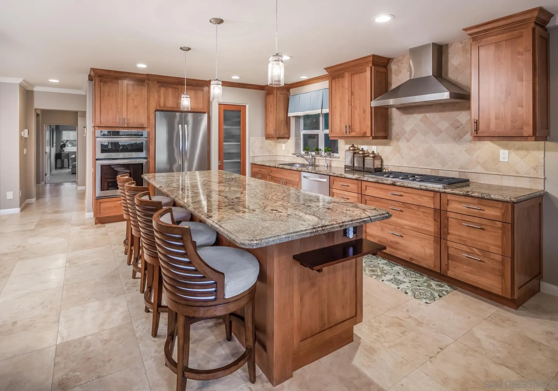 258 Neptune Avenue Encinitas, CA 92024 - Photo 13 of 26 a kitchen with stainless steel appliances granite countertop a table chairs sink refrigerator and cabinets
