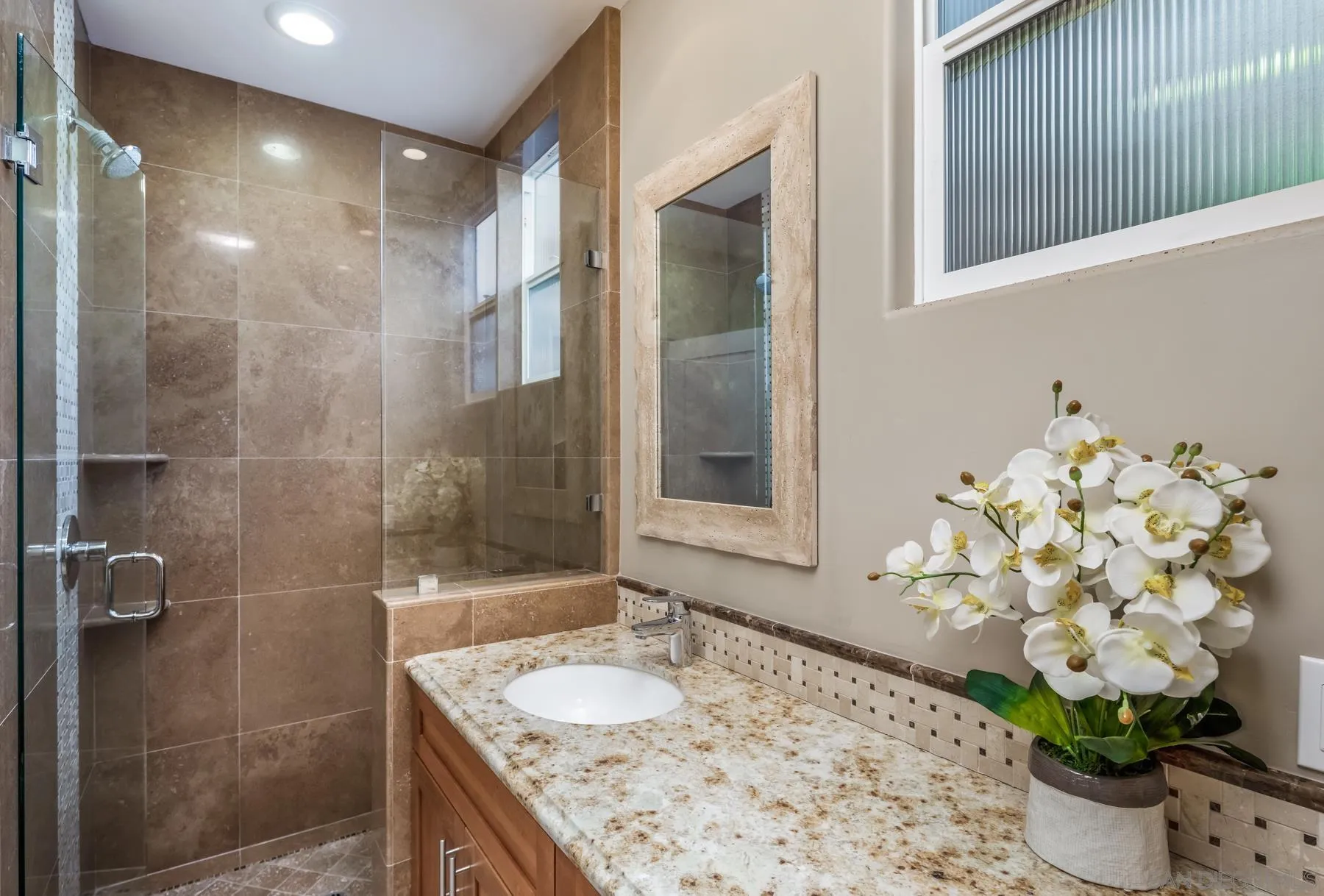 258 Neptune Avenue Encinitas, CA 92024 - Photo 23 of 26 a bathroom with a granite countertop sink a mirror and a shower