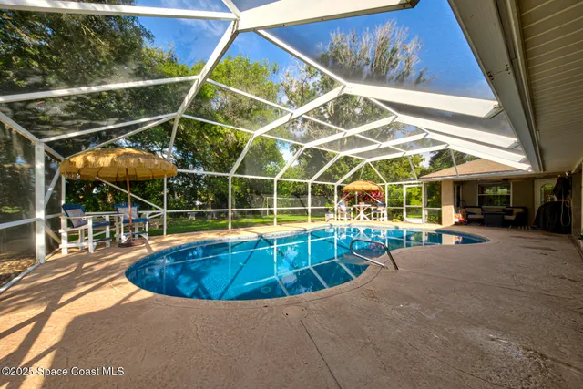 a view of a house with a yard and large tree