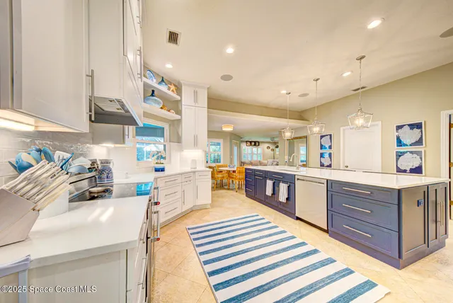 a kitchen with stainless steel appliances granite countertop a table chairs and a chandelier