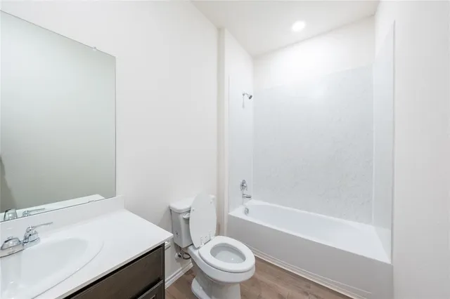 a white toilet sitting next to a bath tub