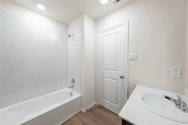 a bathroom with a tub shower and a sink