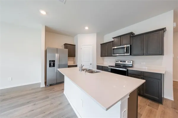 a kitchen with sink a microwave and refrigerator