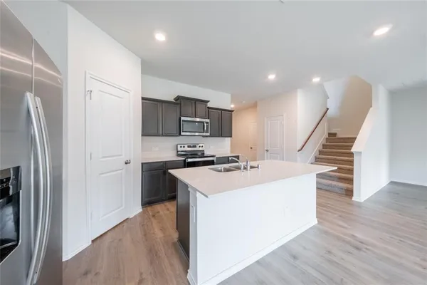 a kitchen with appliances a sink and a refrigerator