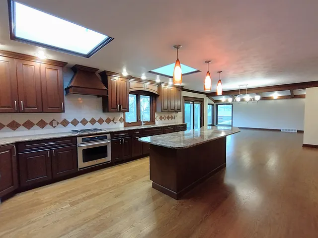 a bathroom with a granite countertop sink a mirror and a shower