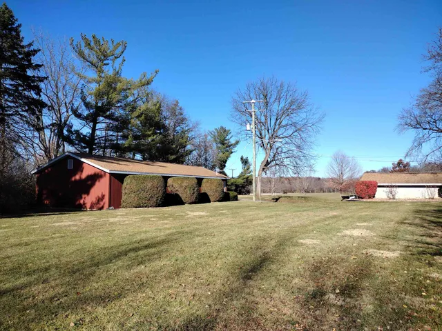 a view of a house with a yard and potted plants