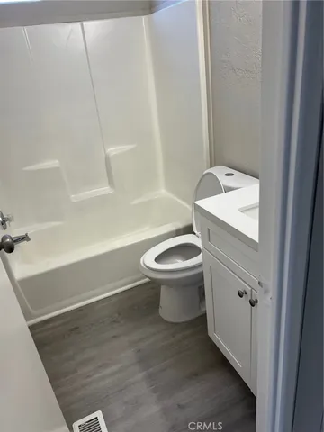 a white toilet sitting next to a bath tub