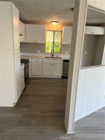 a kitchen with a sink a window and cabinets
