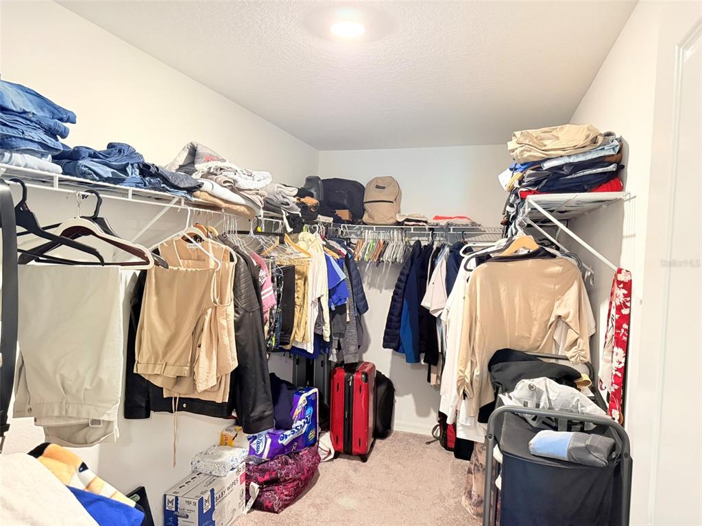 11244 Linden Depot Road San Antonio, FL 33576 - Photo 33 of 41 a view of walk in closet with clothes and shoes