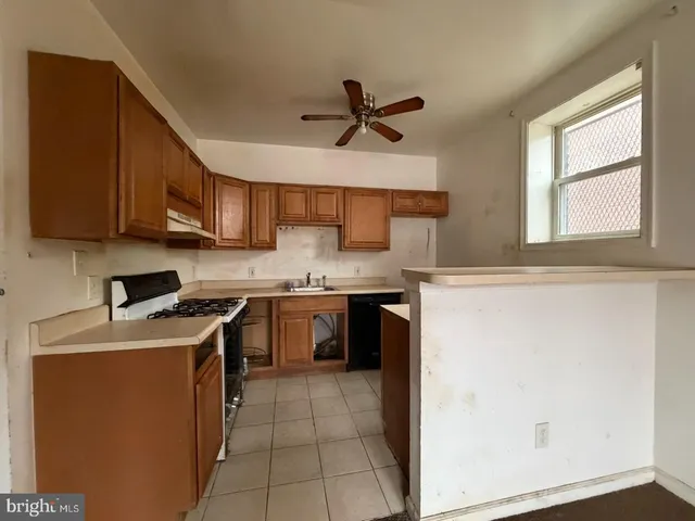 a kitchen with a stove top oven a sink a counter space and cabinets