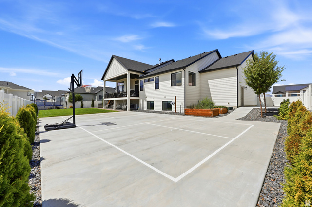4331 West 475 South West Point, UT 84015 - Photo 43 of 46 Expansive concrete pad, covered patio, white siding exterior, dark roof, and manicured green lawn