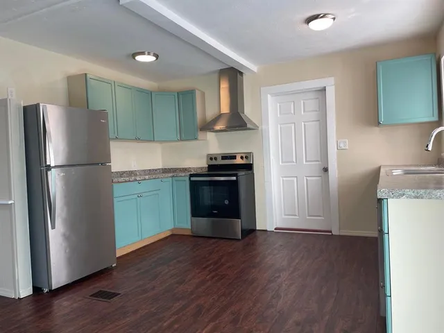a kitchen with a refrigerator and a stove top oven