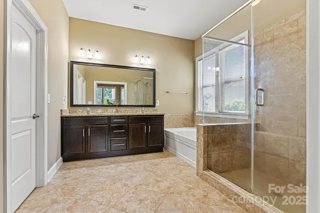 a bathroom with a granite countertop sink mirror and shower