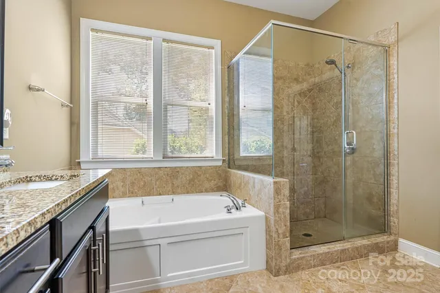 a bathroom with a granite countertop bathtub and shower