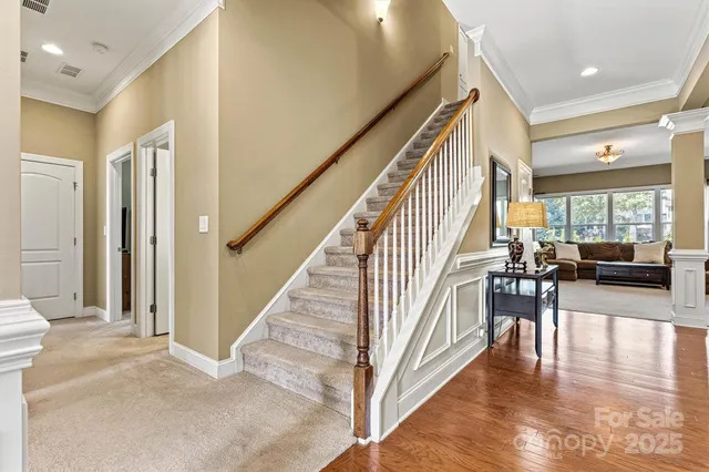 a view of a hallway with wooden floor and staircase