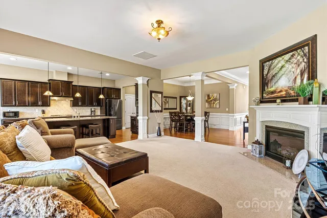 a living room with furniture fireplace and kitchen view