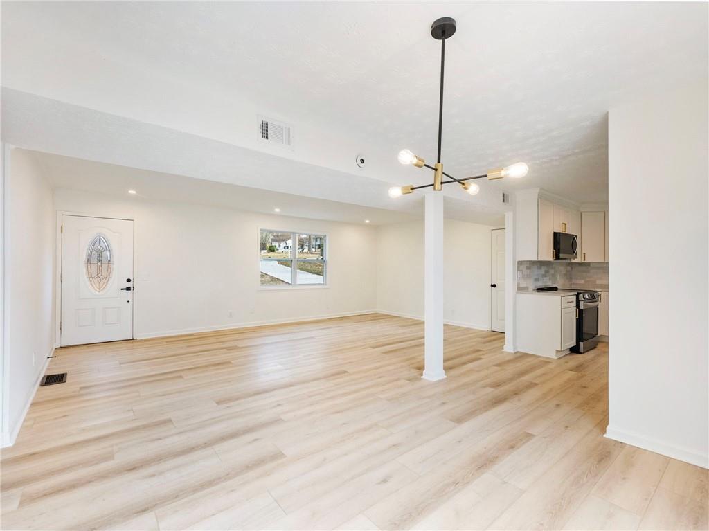 930 Woodbridge Drive Northeast Conyers, GA 30012 - Photo 11 of 38 a view of a kitchen with a stove wooden floor a sink and a ceiling fan