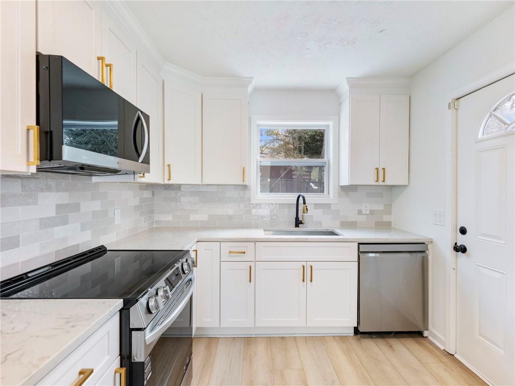930 Woodbridge Drive Northeast Conyers, GA 30012 - Photo 14 of 38 a kitchen with stainless steel appliances granite countertop a sink stove and microwave