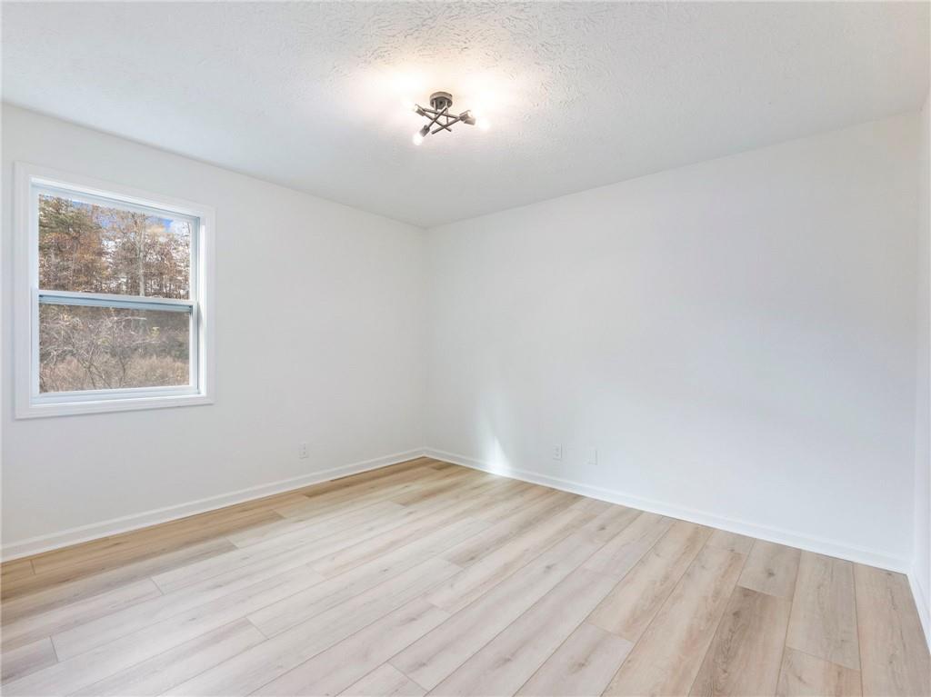 930 Woodbridge Drive Northeast Conyers, GA 30012 - Photo 22 of 38 an empty room with wooden floor and windows