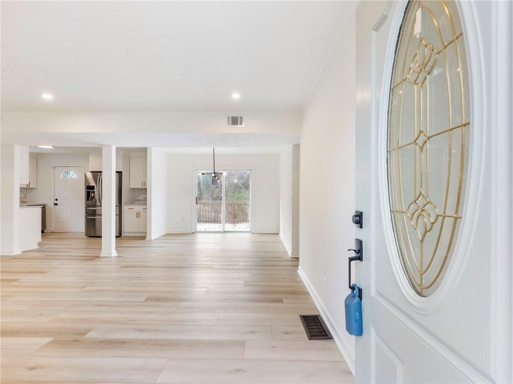 930 Woodbridge Drive Northeast Conyers, GA 30012 - Photo 6 of 38 a view of a hallway with wooden floor windows and a bathroom