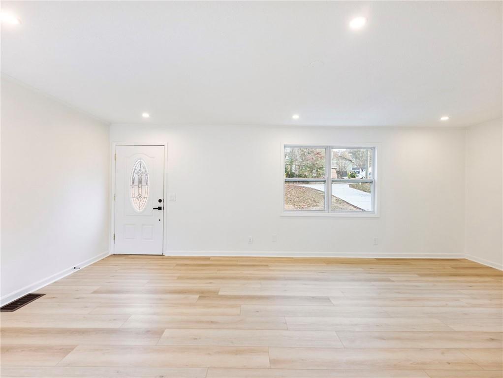 930 Woodbridge Drive Northeast Conyers, GA 30012 - Photo 7 of 38 a view of an empty room with wooden floor and window