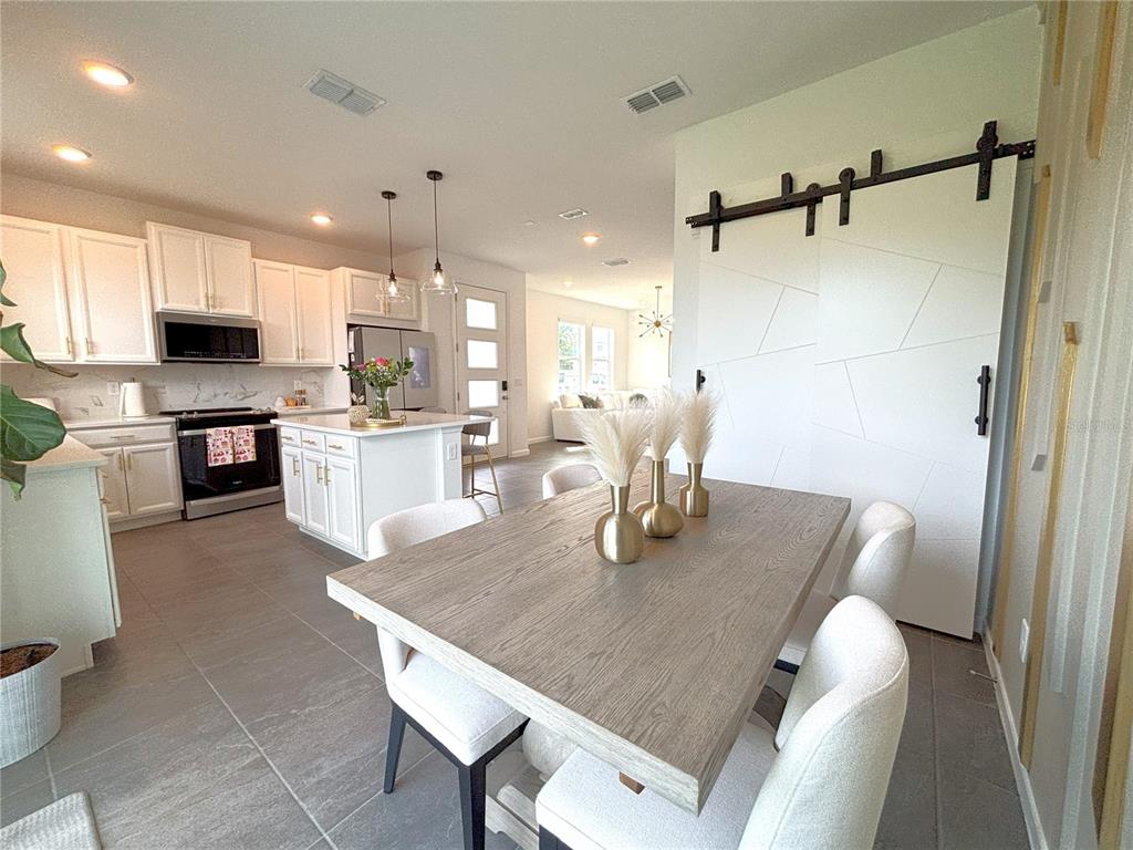 921 Spring Palms Loop Orlando, FL 32828 - Photo 14 of 43 a dining room with kitchen island a table and chairs
