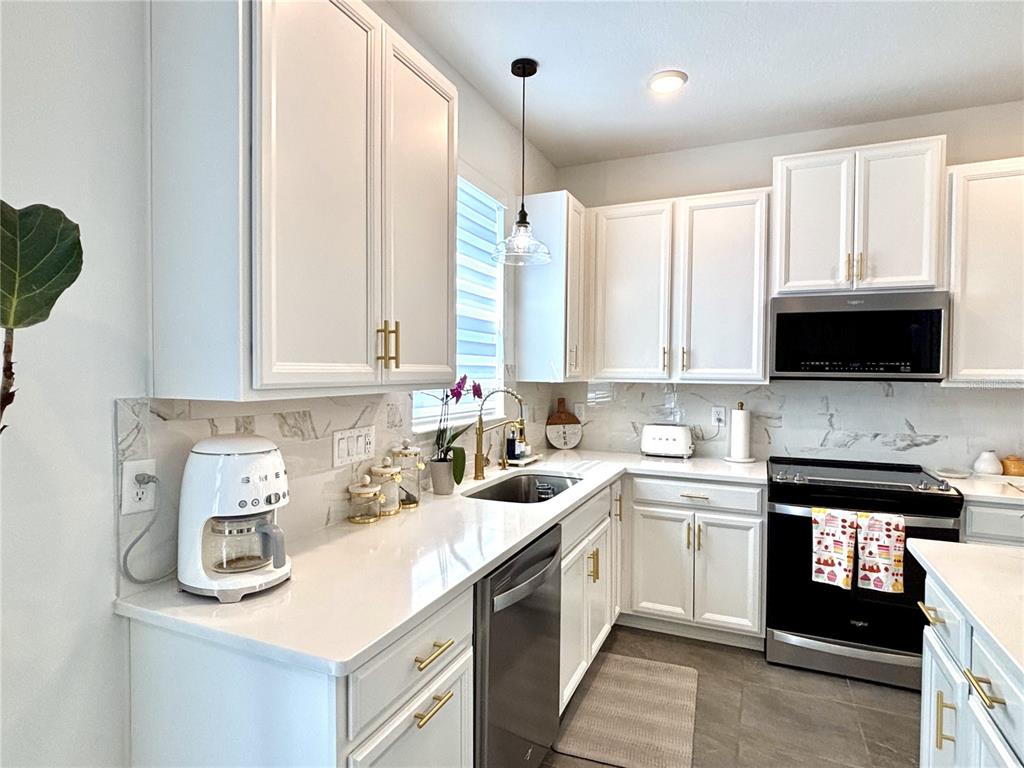 921 Spring Palms Loop Orlando, FL 32828 - Photo 16 of 43 a kitchen with a sink a window and cabinets